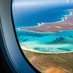 Home 20 카보베르데 항공편 직항 - **Prompt 1: Anticipation of Arrival in Cape Verde**
"A wide-angle shot from inside a modern airp...
